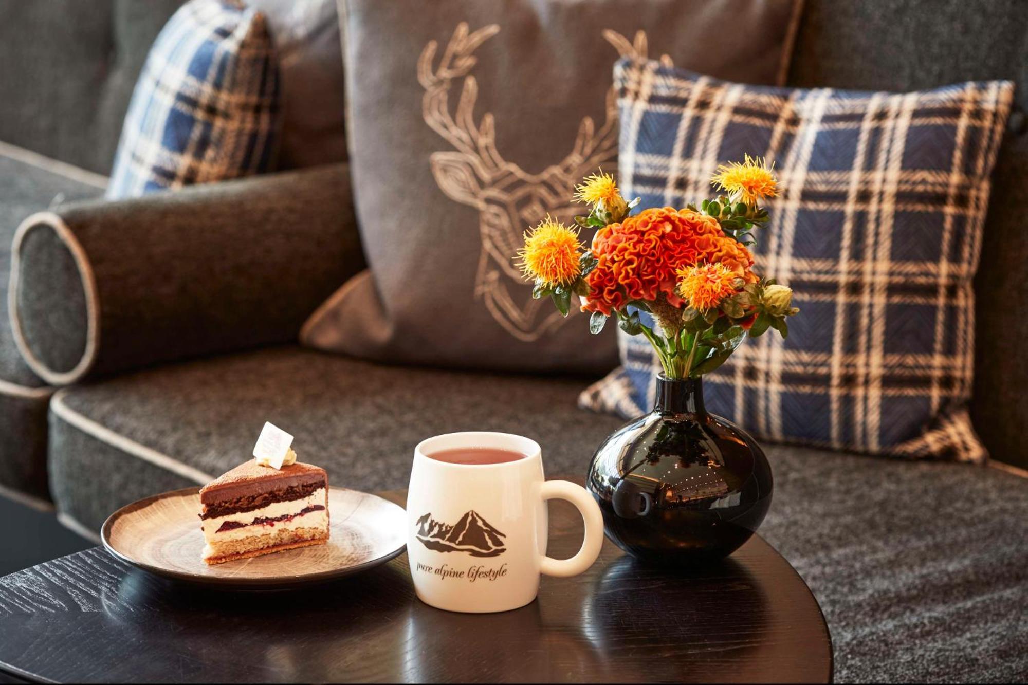 Kempinski Hotel Μπερχτεσγκάντεν Εξωτερικό φωτογραφία A coffee table with a vase of flowers and a cup of coffee